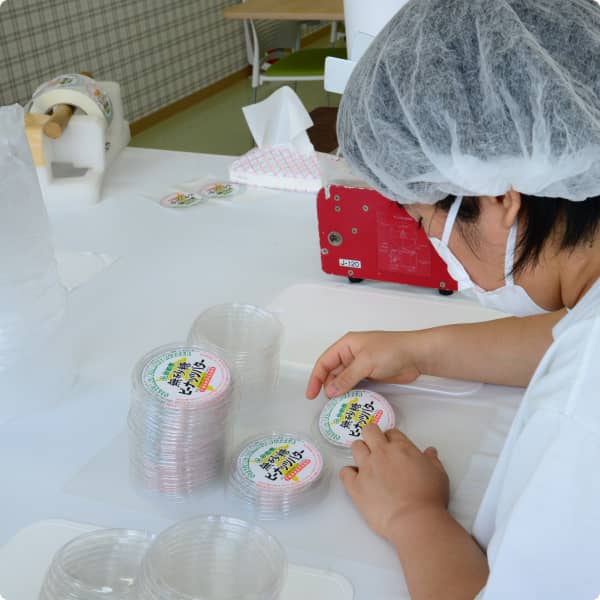 衛生帽とマスクを着用して容器の仕分けを行う様子