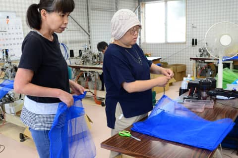 製品作りの作業風景、布やネットを取り扱う2人の女性