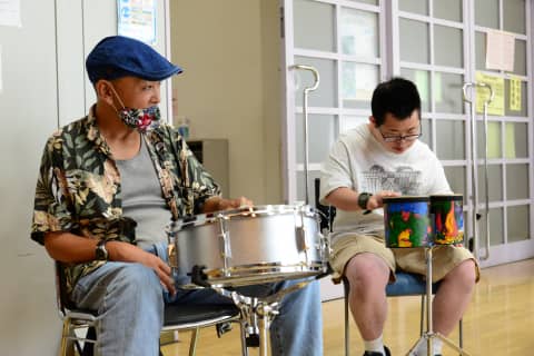 太鼓やドラムを演奏する男性二人、真剣な表情