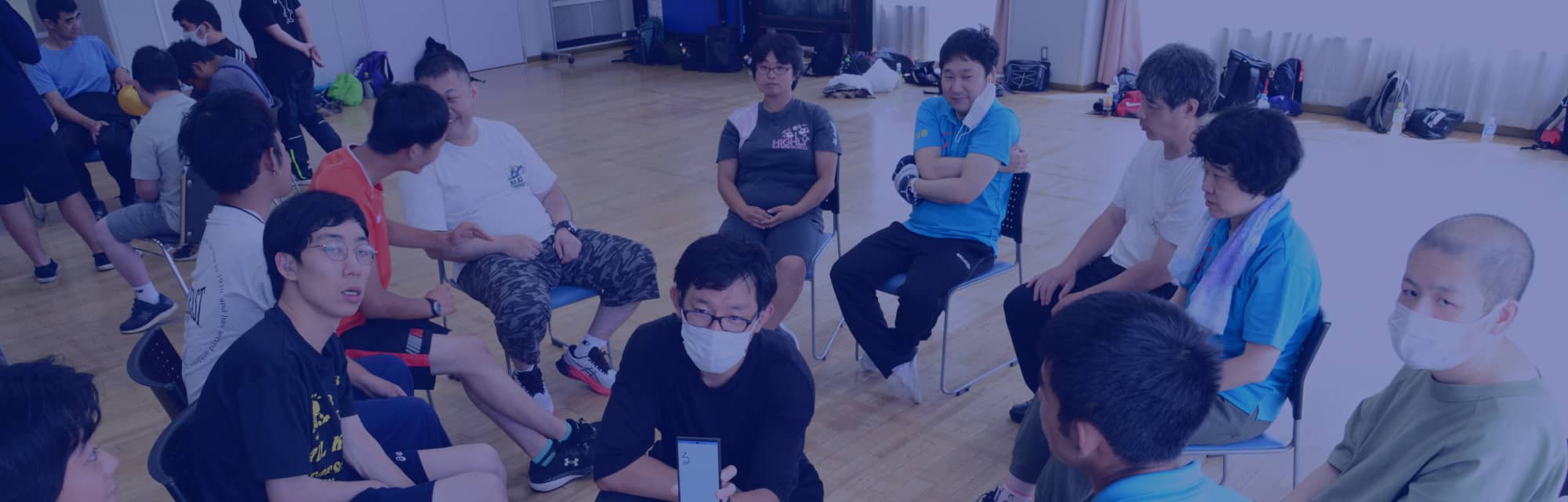 室内で複数の人が円形に座り、リラックスした雰囲気で交流する場面